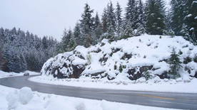 汽車(chē)在白雪皚皚的森林彎道