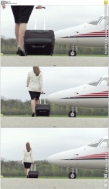 职业女性拖着行李箱走过飞机